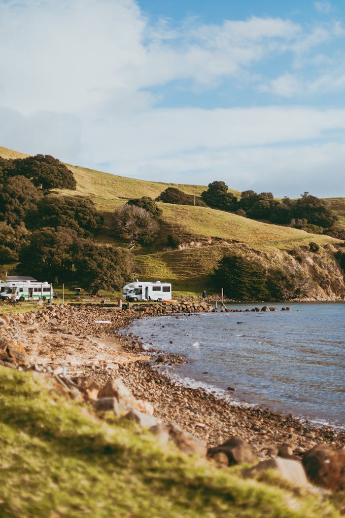 how-it-works Explore the serene coastline of Coromandel with RVs parked by the sea.
