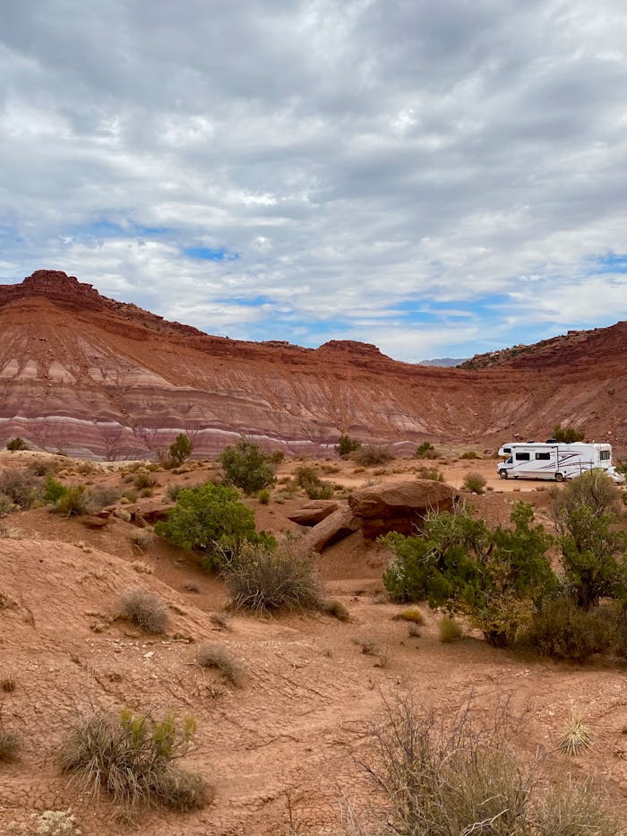 services-04 Campervan parked in a stunning Utah desert landscape with red rock formations.